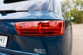 Close up view of led taillights on blue Audi A6 wagon outdoors. Red warning light mounted at rear of vehicle