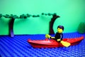 Lego mini-figure rowing boat across the river