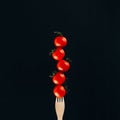 close up view of levitating cherry tomatoes on fork Royalty Free Stock Photo