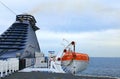 Close-up view of lifeboat on deck of a cruise ship. Orange lifeboat on mounting bracket. Royalty Free Stock Photo