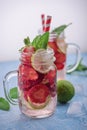 Close up view on lime and strawberry detox drink in glass mason jars on a blue background 2 Royalty Free Stock Photo