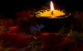 A close-up view of lit Diya placed on table with flowers for celebrating diwali Royalty Free Stock Photo