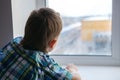 Close up view of little boy looking out of window Royalty Free Stock Photo