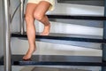 Close up view of little child feet going down the stairs at home, child climbing spiral staircase Royalty Free Stock Photo