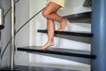 Close up view of little child girl feet going down stairs at home, child climbing spiral staircase Royalty Free Stock Photo