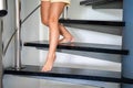Close up view of little girl feet going down stairs at home, child climbing spiral staircase Royalty Free Stock Photo