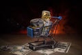 close up view of little shopping trolley full of coins isolated on brown.Gold coins in shopping online cart isolated on brown back Royalty Free Stock Photo