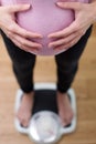 Close Up View Looking Down On Pregnant Woman Standing On Bathroom Scales