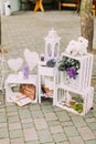 Close-up view of the lovely wedding composition of the vintage candle stands and crates decorated with flowers and