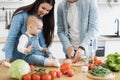 Daughter watching dad making tomato slices on dining table