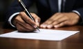 Close-up view of a male hand holding a pen while signing a legal contract with a focused and serious demeanor Royalty Free Stock Photo