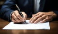 Close-up view of a male hand holding a pen while signing a legal contract with a focused and serious demeanor Royalty Free Stock Photo