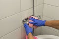 Close up view of man in blue gloves cleaning shower faucet.  Cleaning hygien concept background Royalty Free Stock Photo