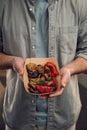 Close up view. Man in casual clothes is holding food that are in the paper eco box. Potatoes, sausages, mushrooms, zucchini Royalty Free Stock Photo