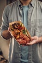 Close up view. Man in casual clothes is holding food that are in the paper eco box. Potatoes, sausages, mushrooms, zucchini Royalty Free Stock Photo