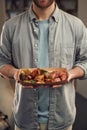 Close up view. Man in casual clothes is holding food that are in the paper eco box. Potatoes, sausages, mushrooms, zucchini Royalty Free Stock Photo