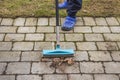 Close up view of man cleaning paving slabs.