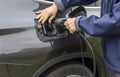 Close up view of man connecting charging cable to charging station for electric car. Royalty Free Stock Photo