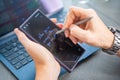 Close up view of man hand holding smart phone and stylus pen at his creative workspace. Royalty Free Stock Photo