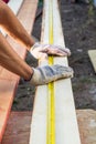 Close up view of a man hands measuring wooden plank with a tape line Royalty Free Stock Photo