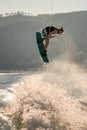 Close-up view of man holding a rope and jumping in the air with wakeboard Royalty Free Stock Photo