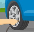 Close up view of man inflating car tyre with air pressure.