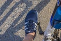 Close-up view of man\'s foot in adidas sneakers on bicycle pedal.