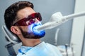 Close up view of man undergoing laser tooth whitening treatment to remove stains and discoloration