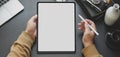 Close-up view of man using blank screen tablet while working in dark modern workplace Royalty Free Stock Photo