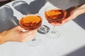 Close up view of man and woman hands holding glasses with cocktail of orange color Royalty Free Stock Photo
