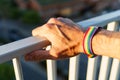 close-up view of a man& x27;s hand with an LGBT rainbow wristband.