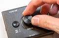 Close-up view of a mans hand turning up adjusting the volume knob on a modern audio device. Making audio output quieter or louder Royalty Free Stock Photo