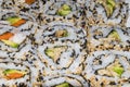 Close up view of many portions of freshly cut sushi of different colors and flavors ready to eat