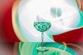 Close up view of martini glass with ice set against abstract green-white-red background Royalty Free Stock Photo