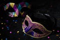 Close-up view of Masquerade mask with confetties on black background