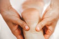 Close-up view masseur hands doing feet massage. Selective focus