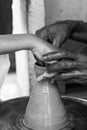 Close up view of a master potter teaching a kid on how to make a pitcher on a pottery wheel, Chennai, India, Feb 25 2017