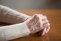 Close up view of mature female wrinkled hands on table