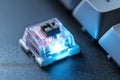 Close-up view of a mechanical keyboard switch with blue LED lighting highlighting its design and function Royalty Free Stock Photo