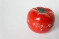 Close up view of mechanical tomato shaped kitchen clock timer for cooking and studying. Used for pomodoro technique for time and
