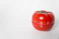 Close up view of mechanical tomato shaped kitchen clock timer for cooking and studying. Used for pomodoro technique for time and