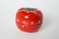 Close up view of mechanical tomato shaped kitchen clock timer for cooking and studying. Used for pomodoro technique for time and Royalty Free Stock Photo