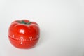 Close up view of mechanical tomato shaped kitchen clock timer for cooking and studying. Used for pomodoro technique for time and Royalty Free Stock Photo