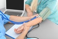 Close up view of medical assistant measuring patient blood pressure in clinic Royalty Free Stock Photo