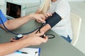 Close up view of medical assistant measuring female patient blood pressure Royalty Free Stock Photo