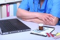 Close-up view of medical doctor working table. Laptop, stethoscope, assorted pils and patient information form Royalty Free Stock Photo