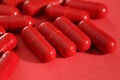 Close-up view of medicine red capsules or pills on red background