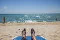 Close-up view of men's feet on sun bed in focus on blurred ocean water background. Miami Beach. Royalty Free Stock Photo