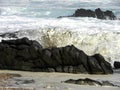 Milky sea foam waves on rocks.