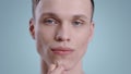 Close up view of millennial man touching his face while looking to camera . Portrait of male handsome model with naked